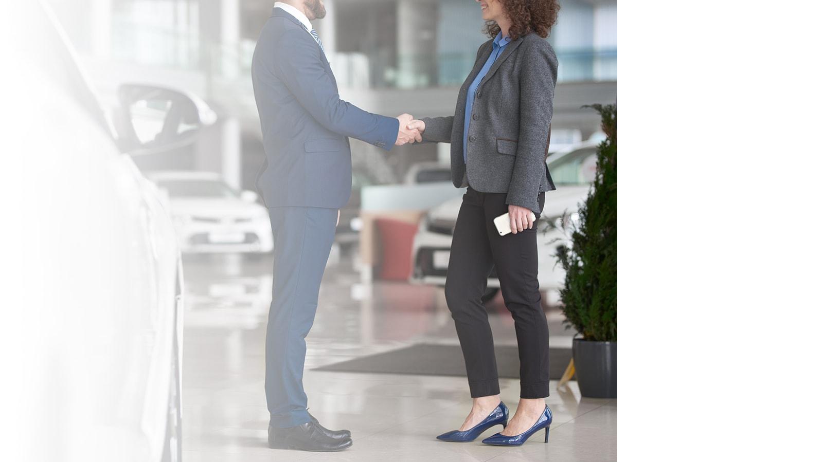 Dealership associate shaking hands with a customer