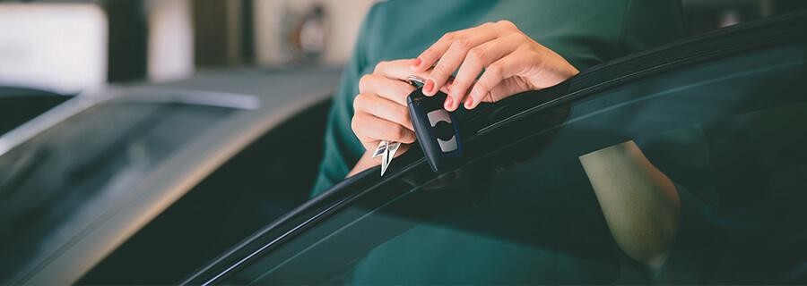 Woman holding keys to a new car.