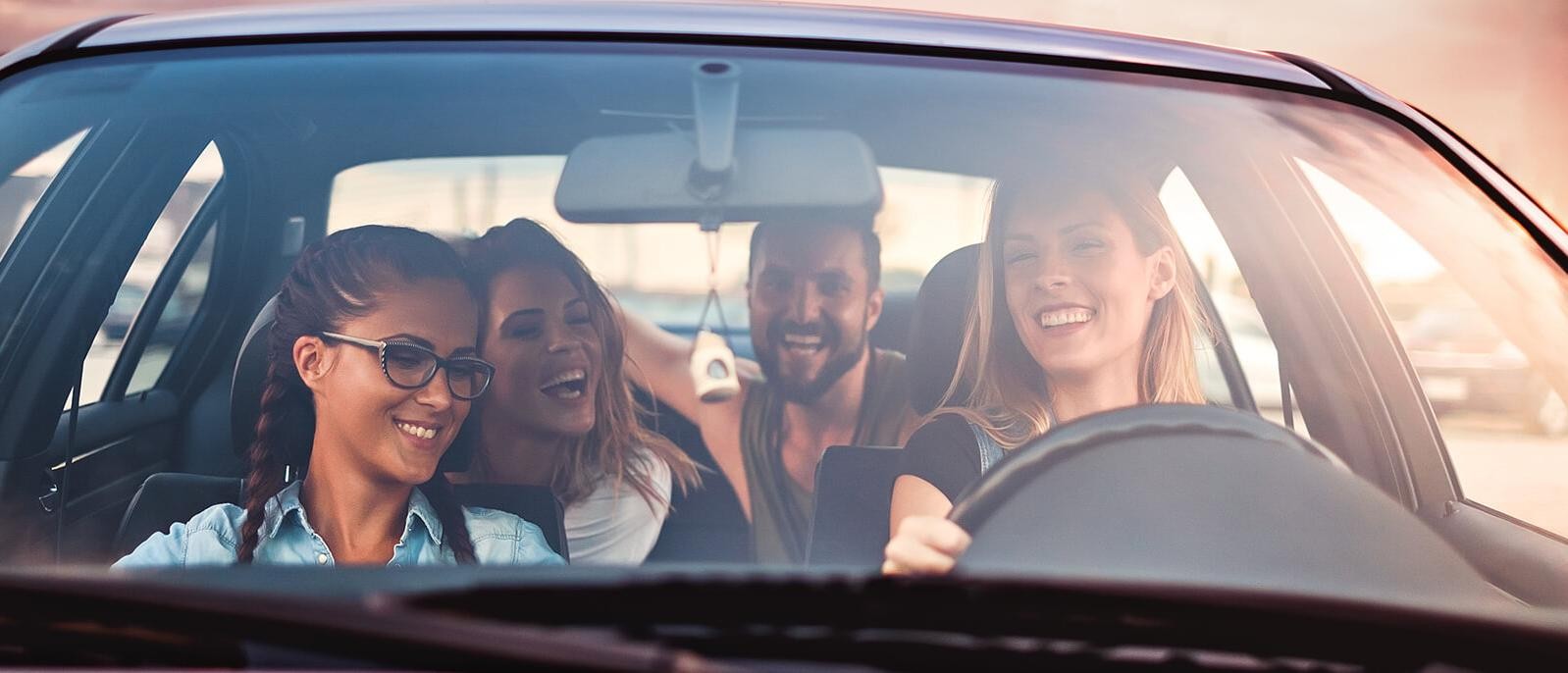 Young friends driving in a car