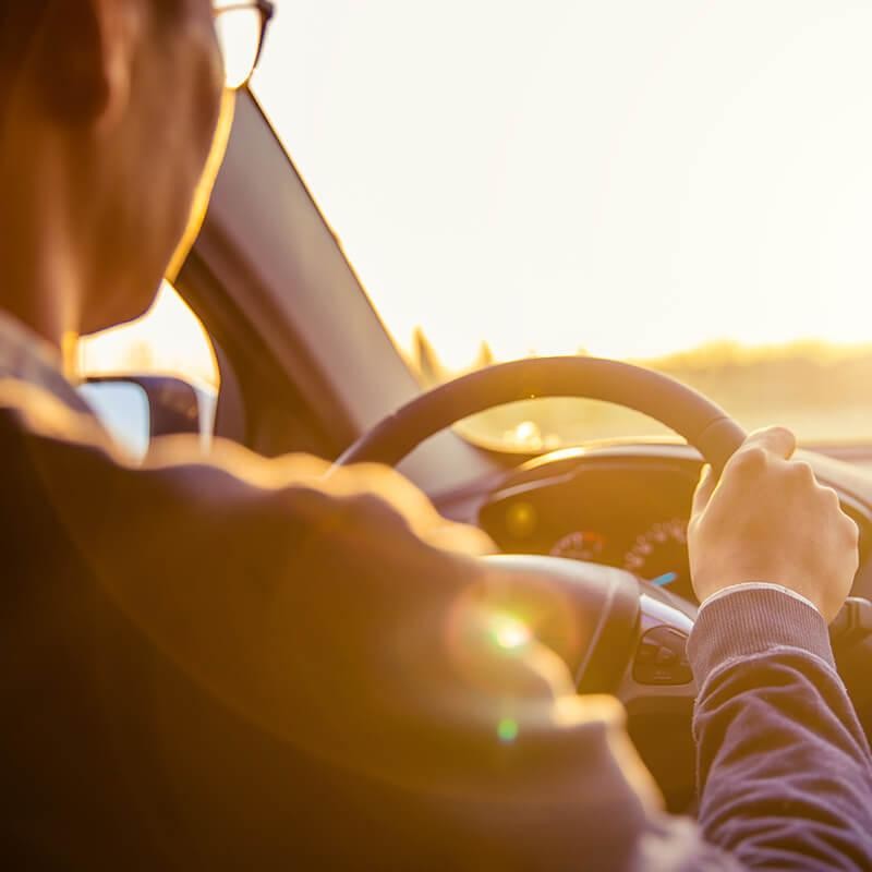 Man driving a car at daybreak