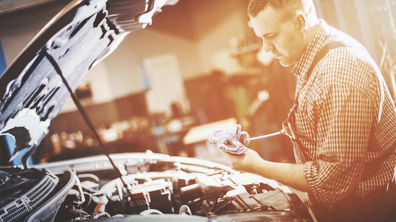 Service mechanic checking an engine's oil