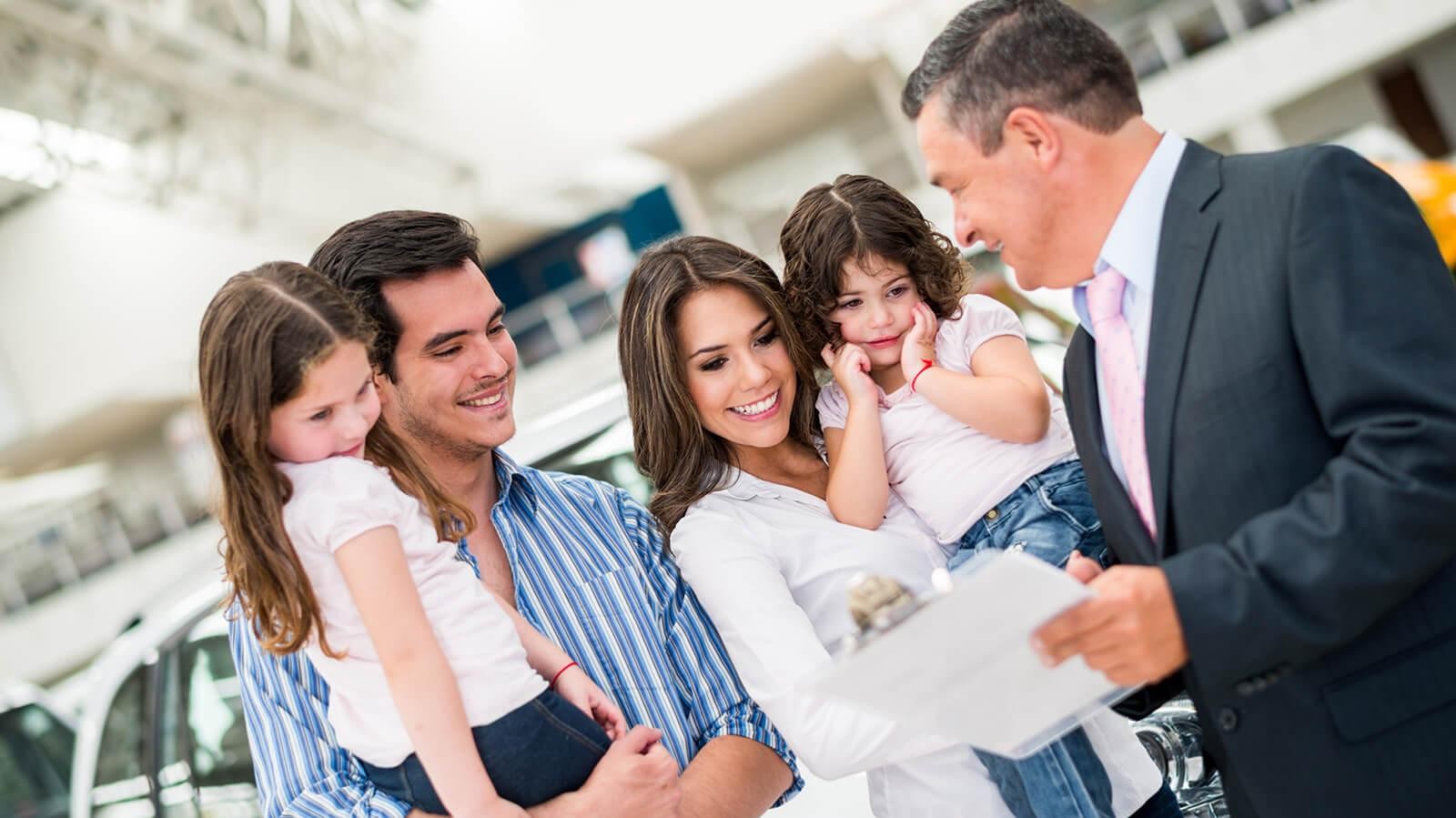 Family talking with a dealership sales associate