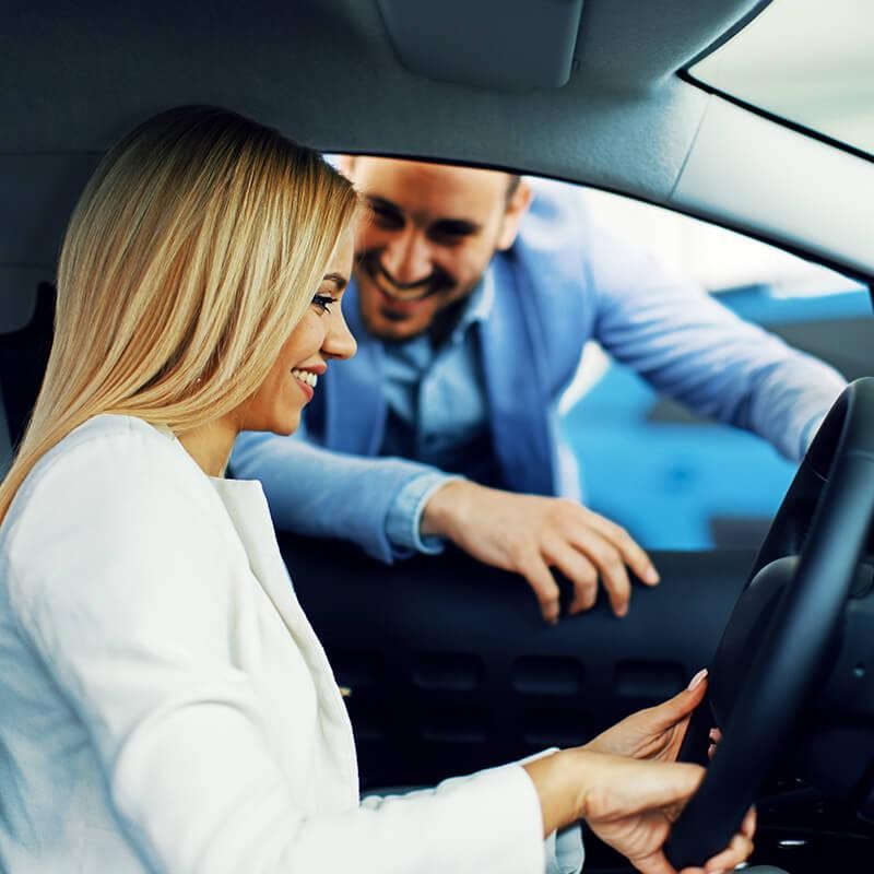 Woman test driving a vehicle in a dealership