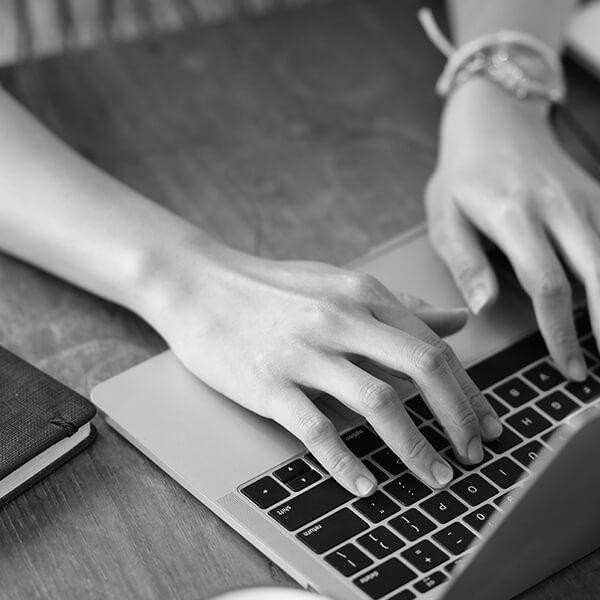 Hands typing on a laptop computer