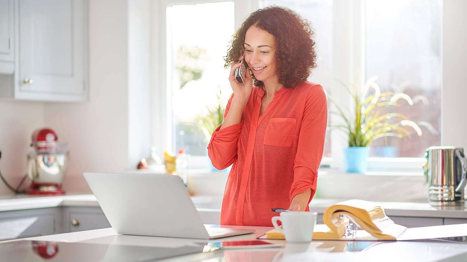 Woman in her kitchen, on the phone