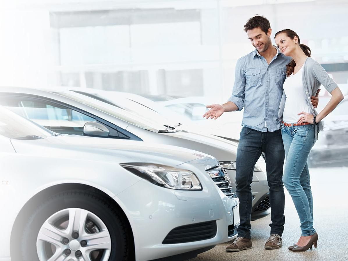 Young couple contemplating buying a new car