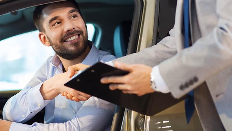 Customer shaking hands with a dealership sales associate