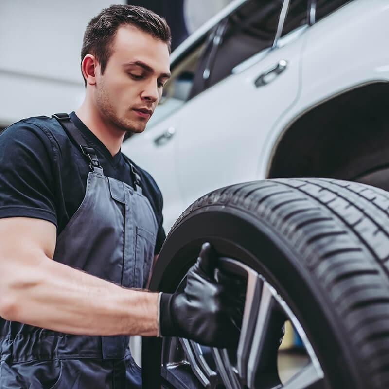 Service mechanic holding a vehicle tire