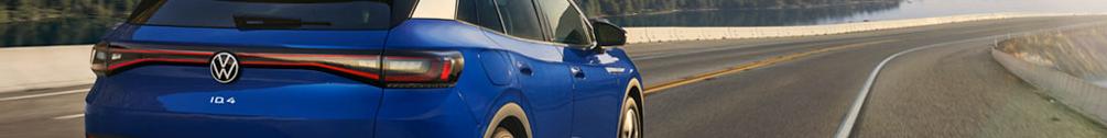 A wide shot of an ID.4 in Dusk Blue Metallic driving along an open highway.
