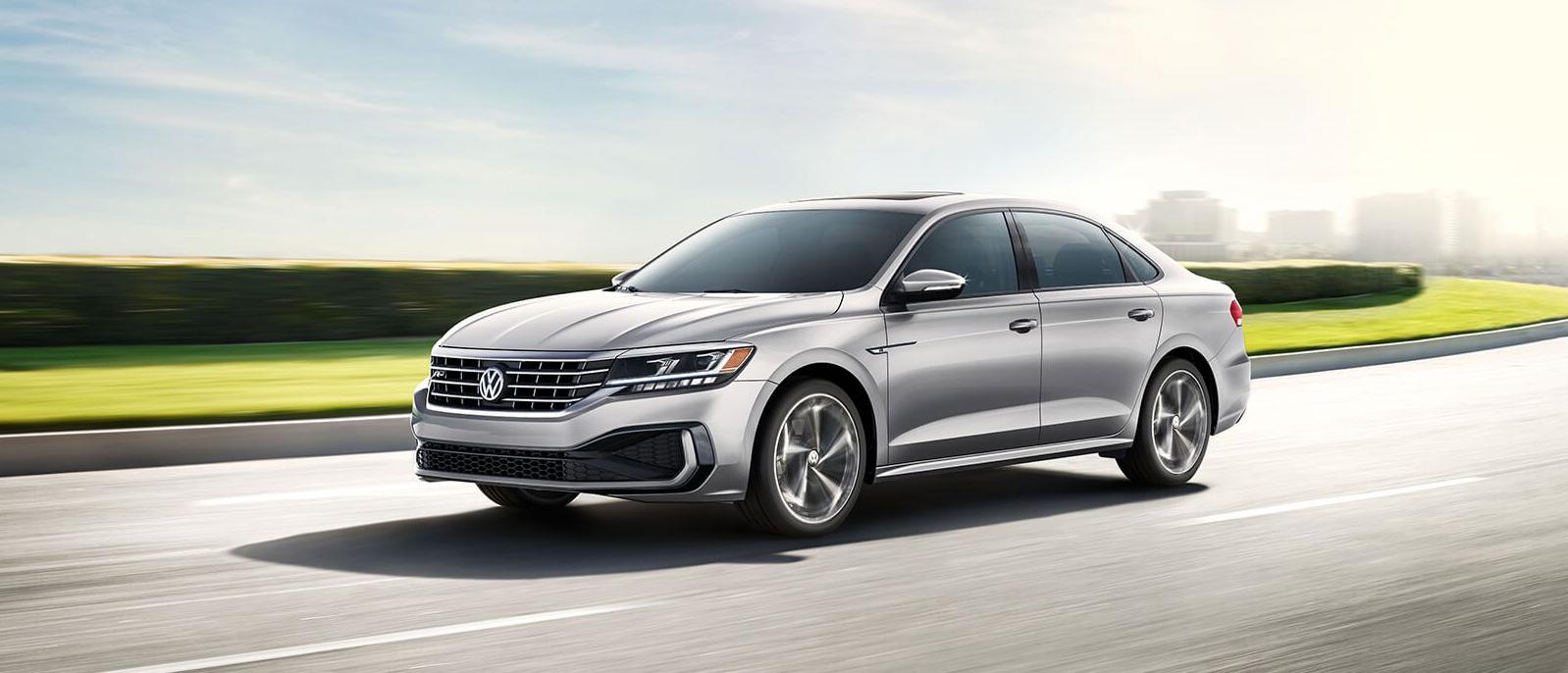 A silver Passat is riding out of a city. A silver Passat is riding out of a city.