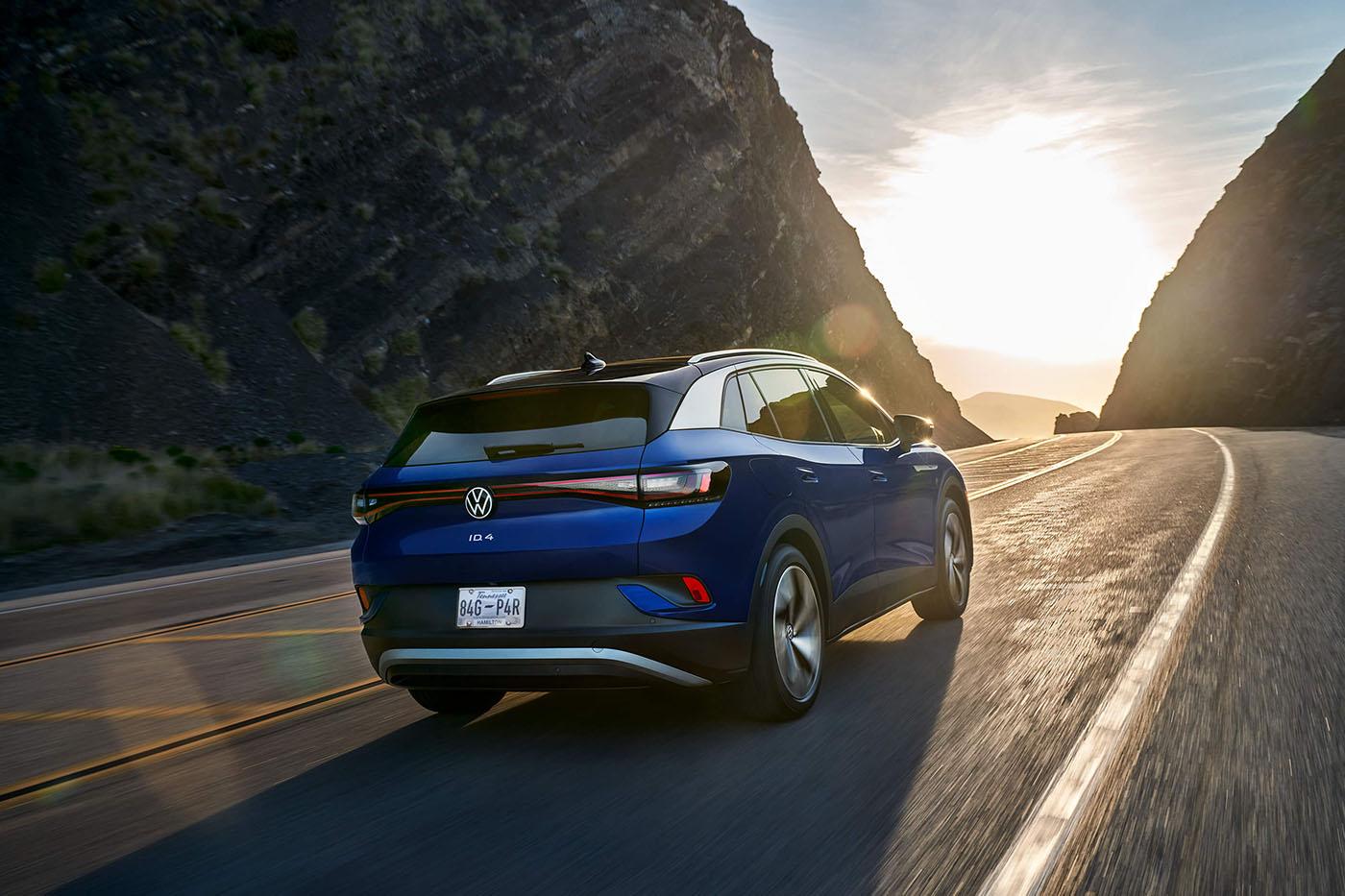 A rear view of an ID.4 in Dusk Blue Metallic, driving along a mountain road.