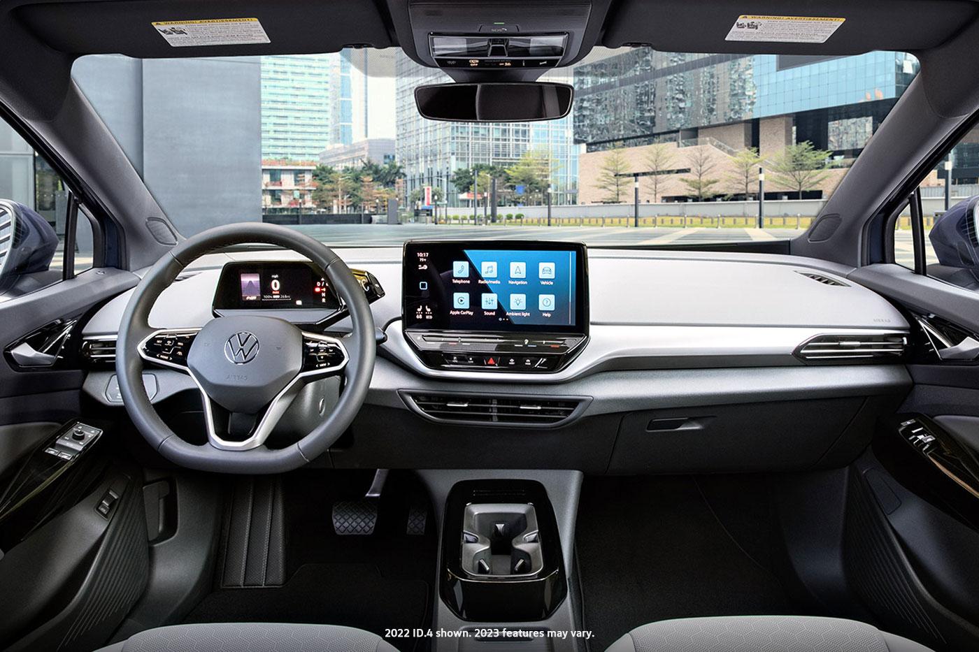 Interior shot of an ID.4 with focus on the front windshield, the dashboard,steering wheel, cup holder and center console display.