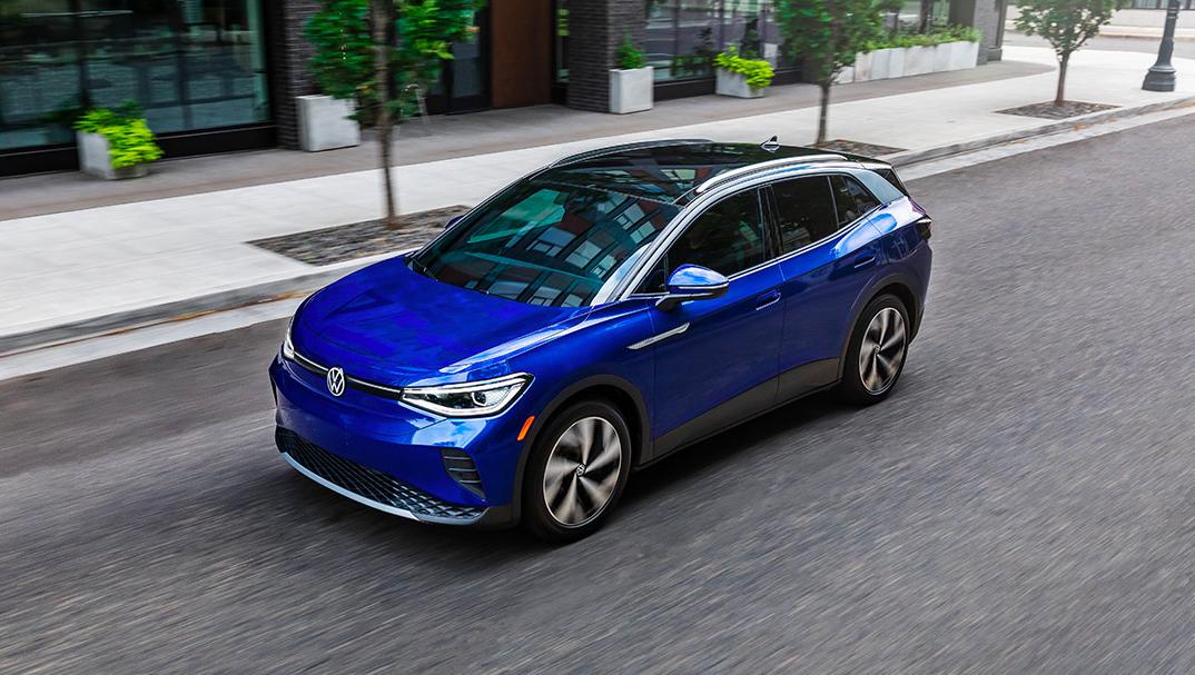 A driver’s side, angled profile shot of an ID.4 in Dusk Blue Metallic parked on an urban street.