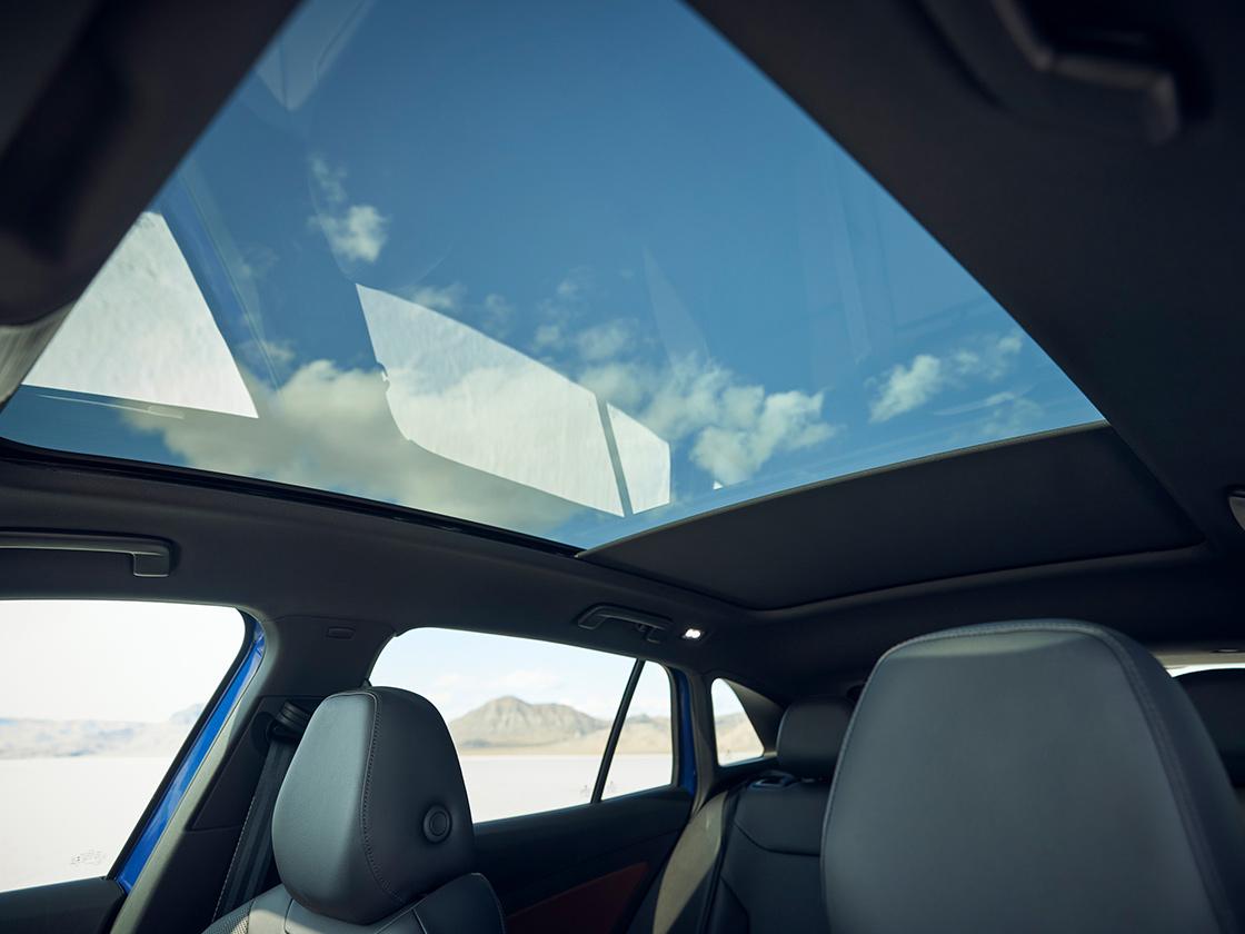 Interior shot of an ID.4 with focus on the glass roof, sunshade, passenger side windows, and front seat headrests.