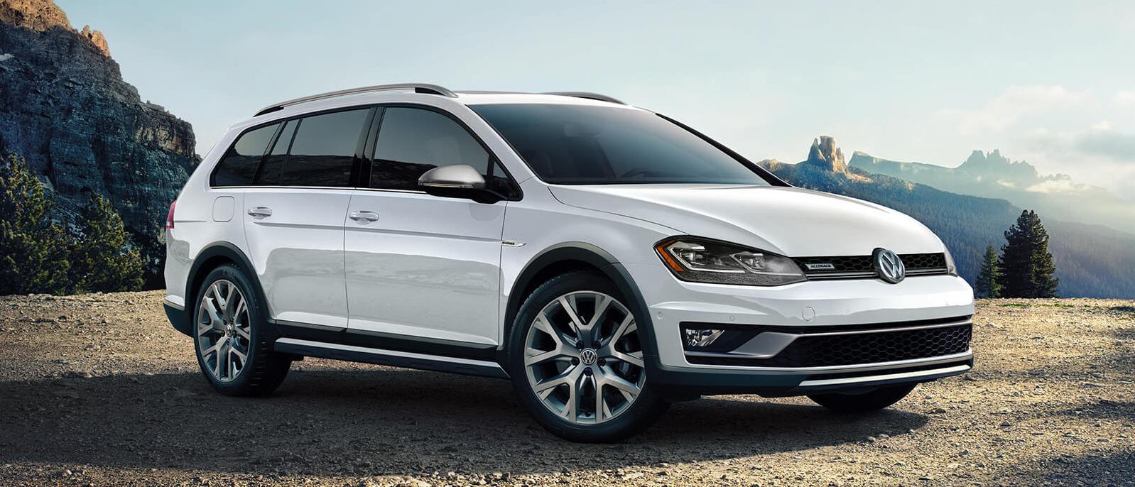 A white Golf Alltrack parked at a scenic mountain overlook. A white Golf Alltrack parked at a scenic mountain overlook.