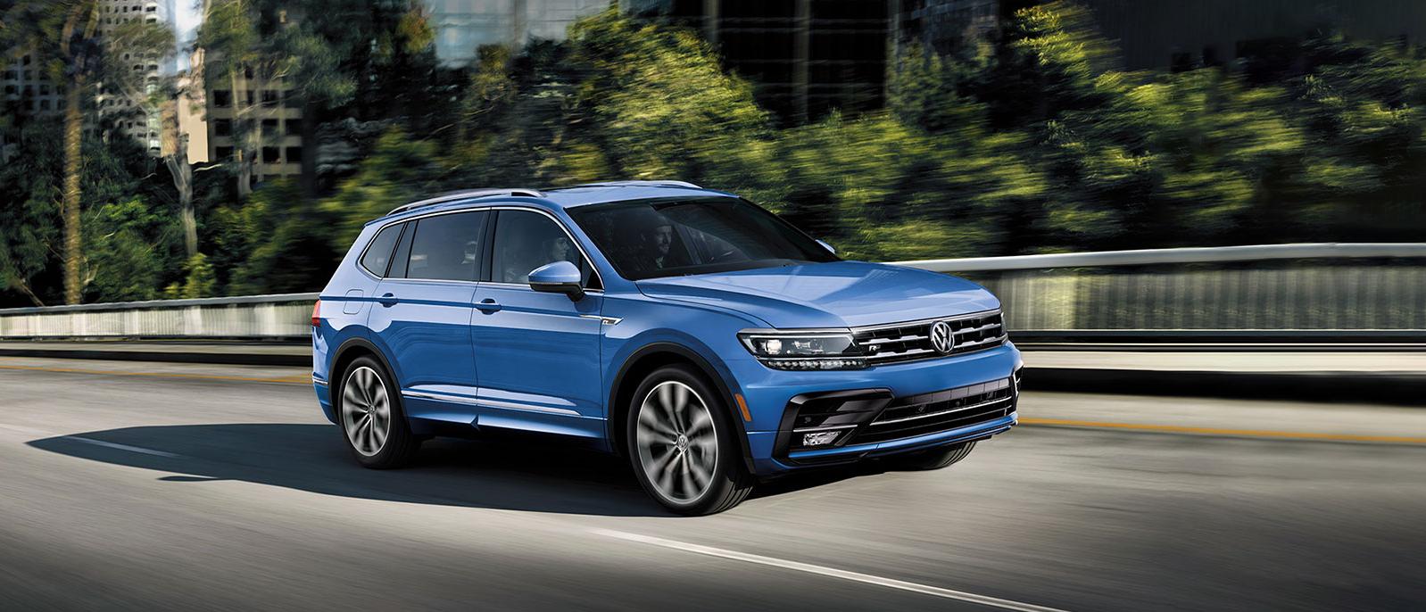 A blue Tiguan is crossing a bridge A blue Tiguan is crossing a bridge