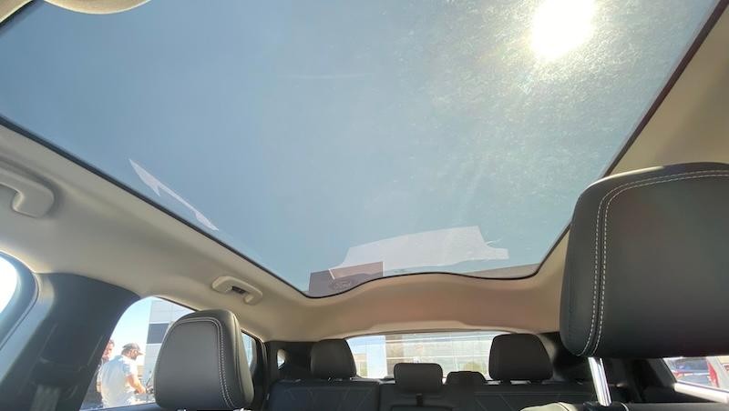 Sun shining through open moonroof on white Mustang Mach-E