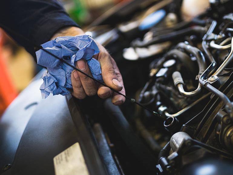 Technician checking oil