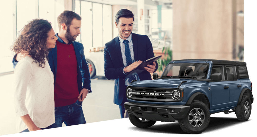 Young woman and her husband in the showroom purchasing new car