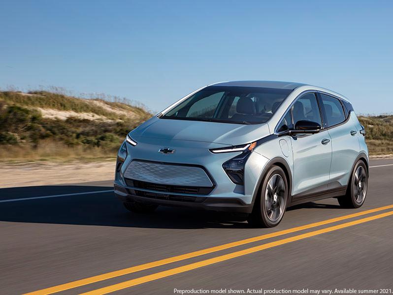 A new Chevrolet Bolt EV driving down a road.
