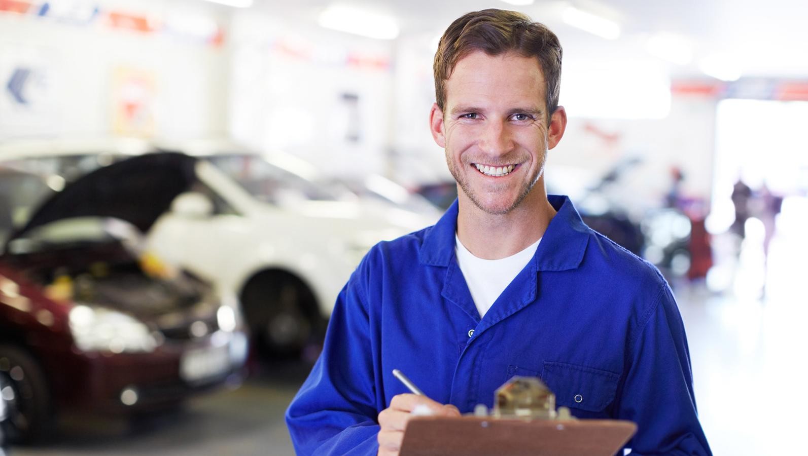 Portrait of a diligent mechanic holding a clipboard in an auto repair shop