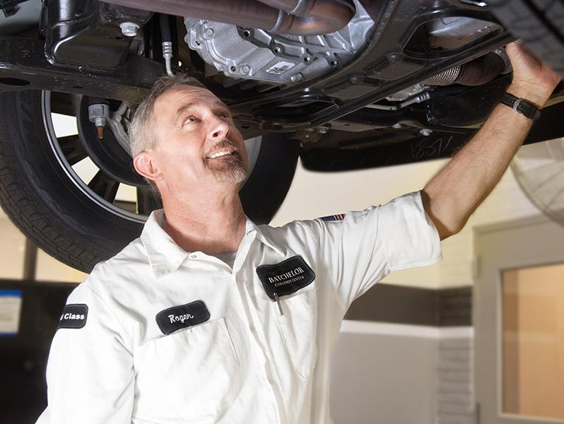 Sewell Technician examining the bottom of a vehicle