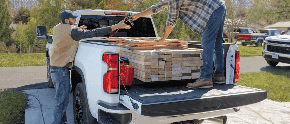 A Chevy commercial truck has materials unloaded from its bed.