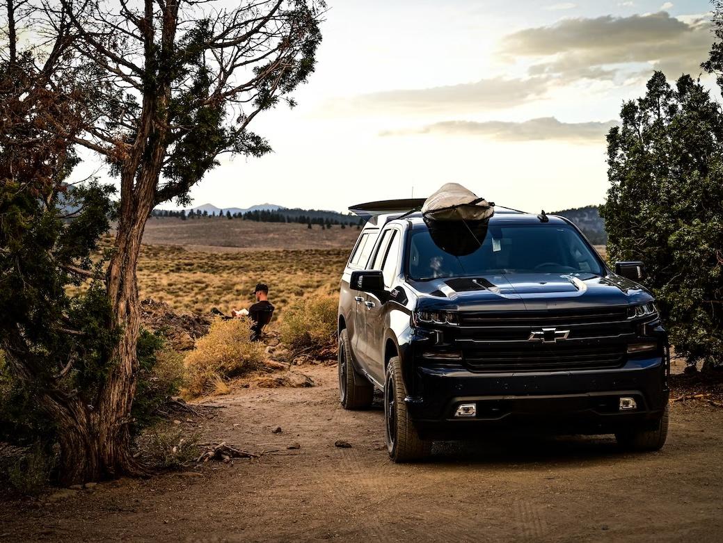 A black 2023 Chevrolet Tahoe parked in a wilderness setting