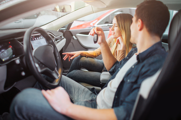 couple driving their new car for the first time after purchase