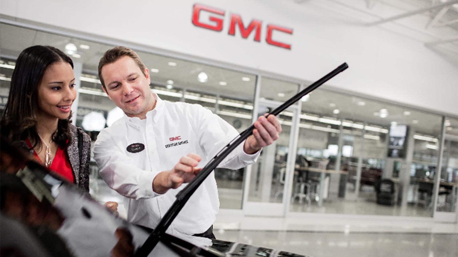 Service technician inspecting a GMC Sierra 1500 Denali.