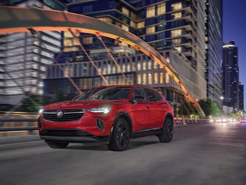 A new Envision SUV drives through the city at night.