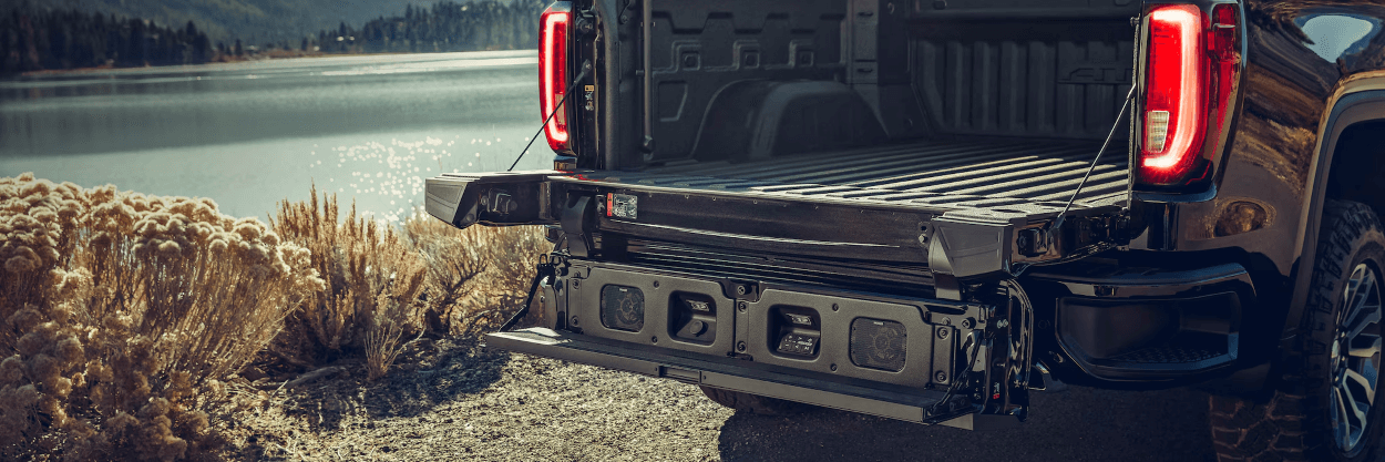 How do you use the tailgate audio system on a GMC truck?