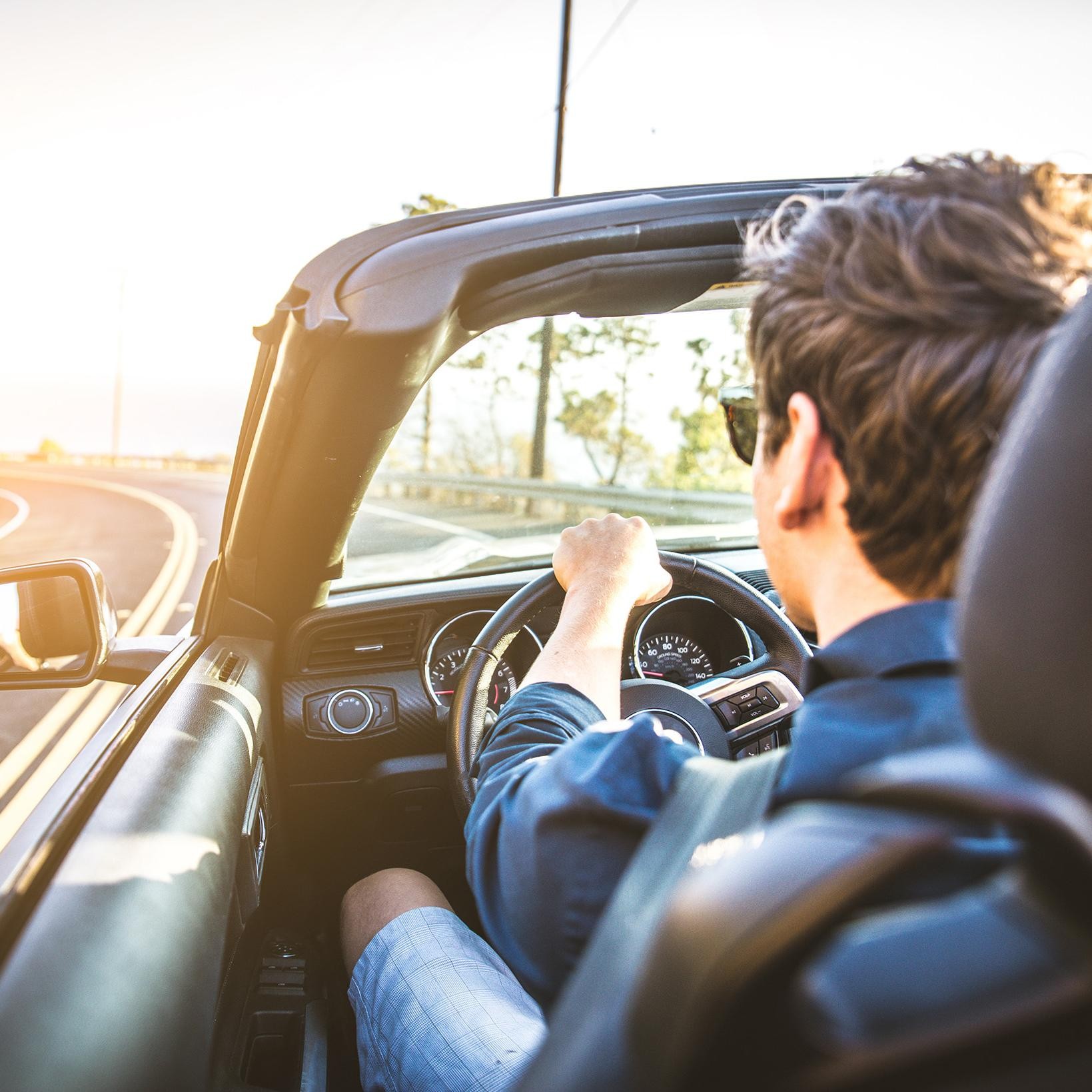 Man driving a car at daybreak