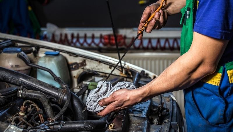 Mechanic checking oil at Gerry Lane Buick GMC