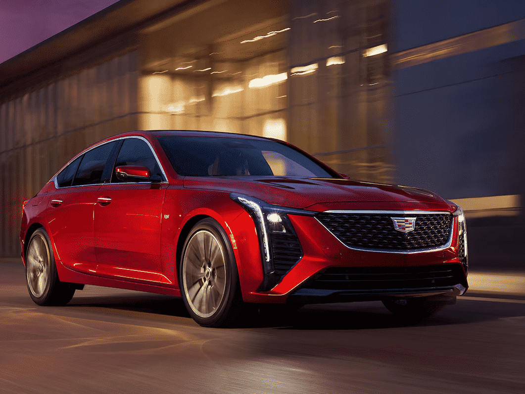 A new Cadillac car, the 2025 Cadillac CT5 is driving down the road.