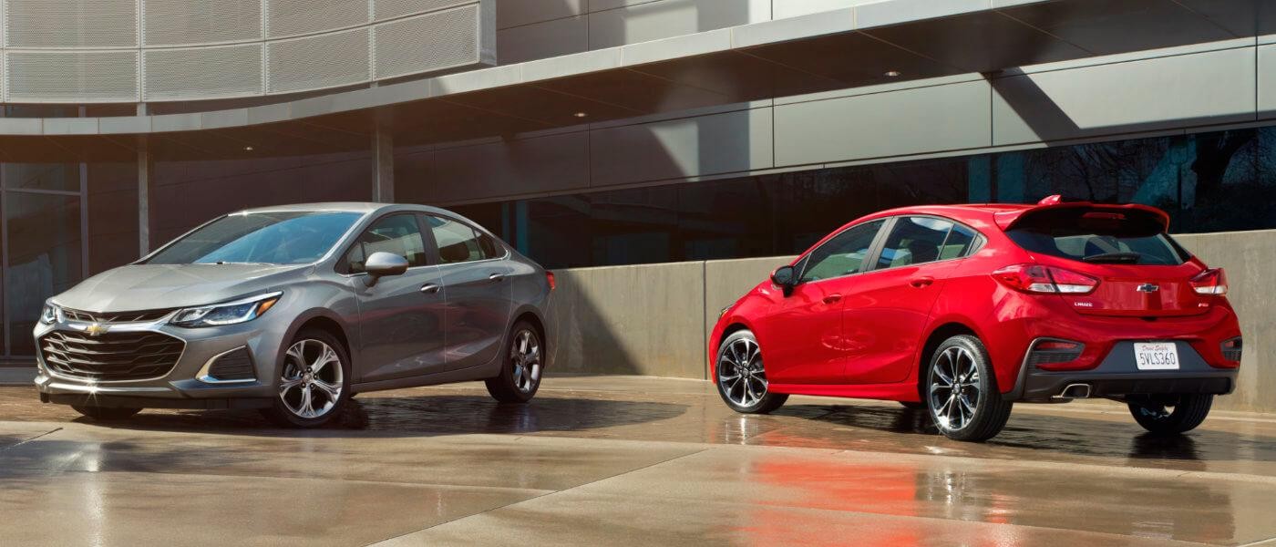 Two 2019 Chevy Cruze Sedans Parked in Front of a Building
