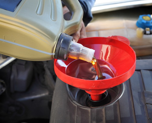 mechanic pouring synthetic oil into car engine