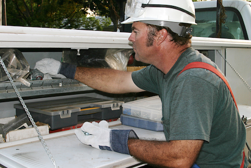 Male working reaching into his truck toolbox.