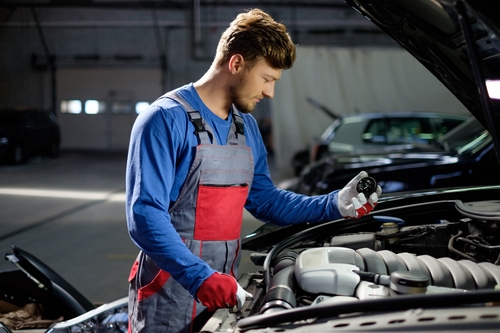 mechanic performing maintenance on car