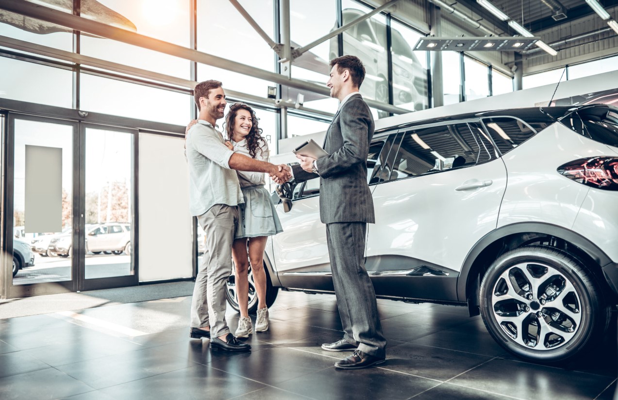 Couple getting the keys to their new car.