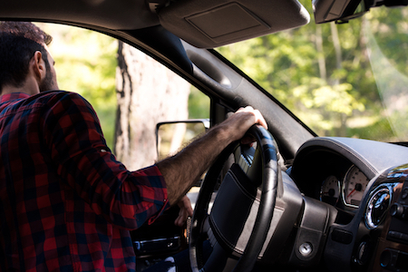 man looking out of his truck window