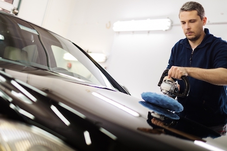 man buffing his car