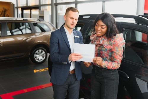 African American woman reviewing car financing contract