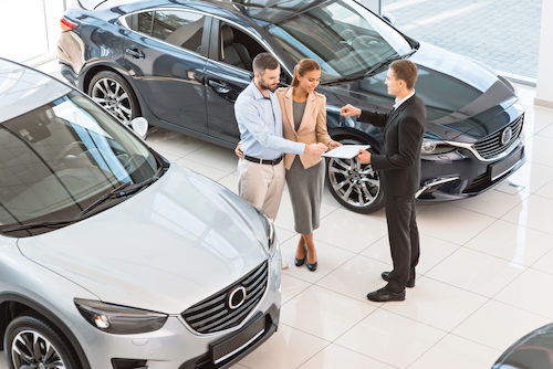 Couple getting the keys to their new car.