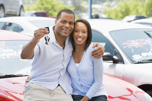 African American couple holding keys to their new used car