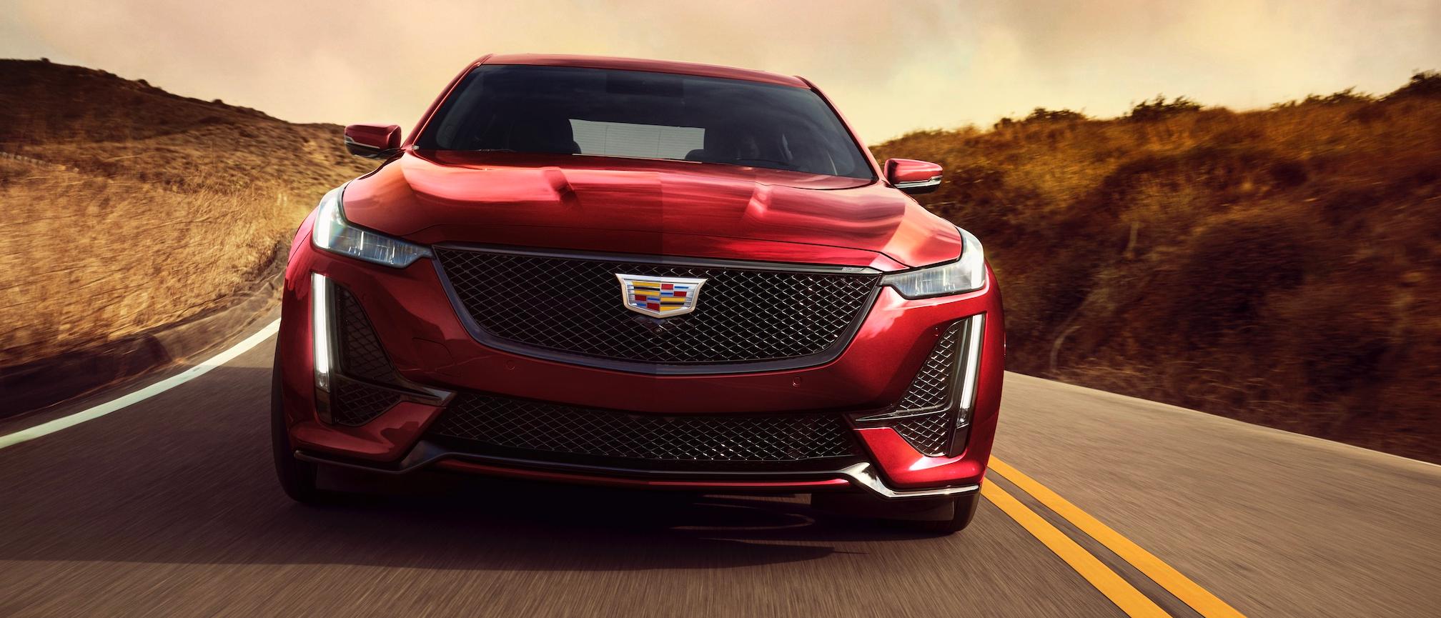 Cadillac 2024 CT5-V in Radiant Red; Grille Header Badge; front view of vehicle in motion