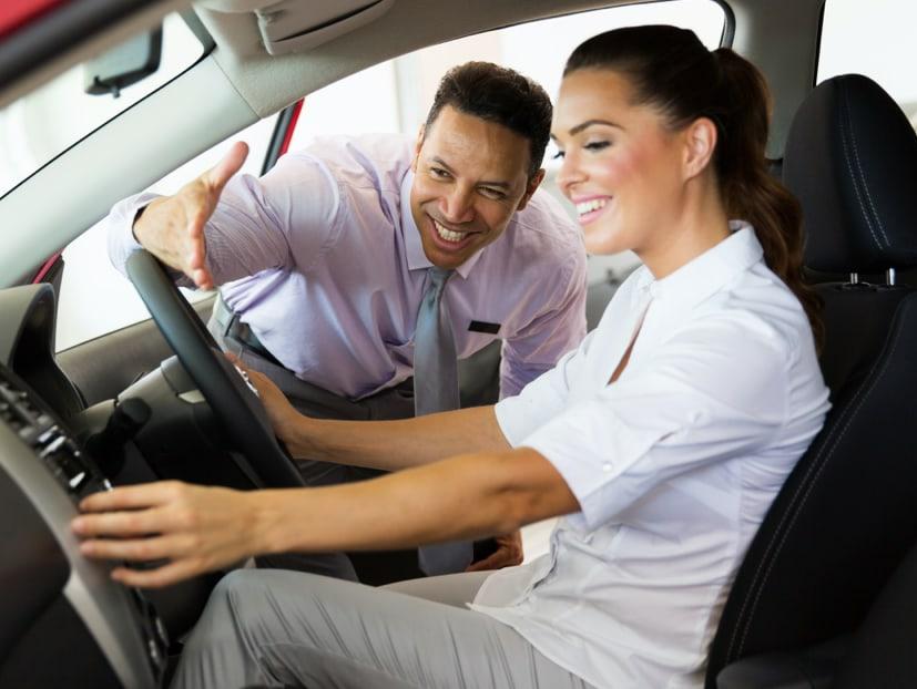 car dealer explaining features to a lady customer