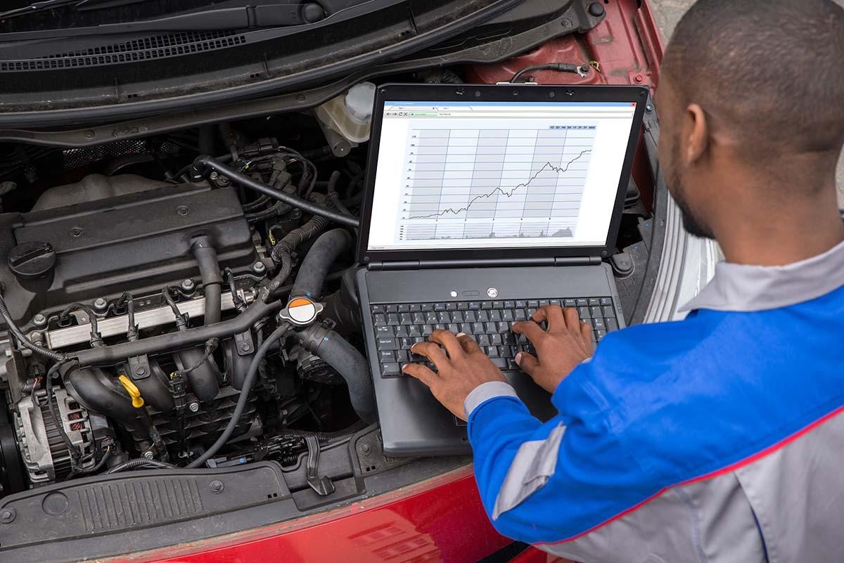 Service mechanic greeting a woman at her door and a mechanic working on a vehicle in a garage