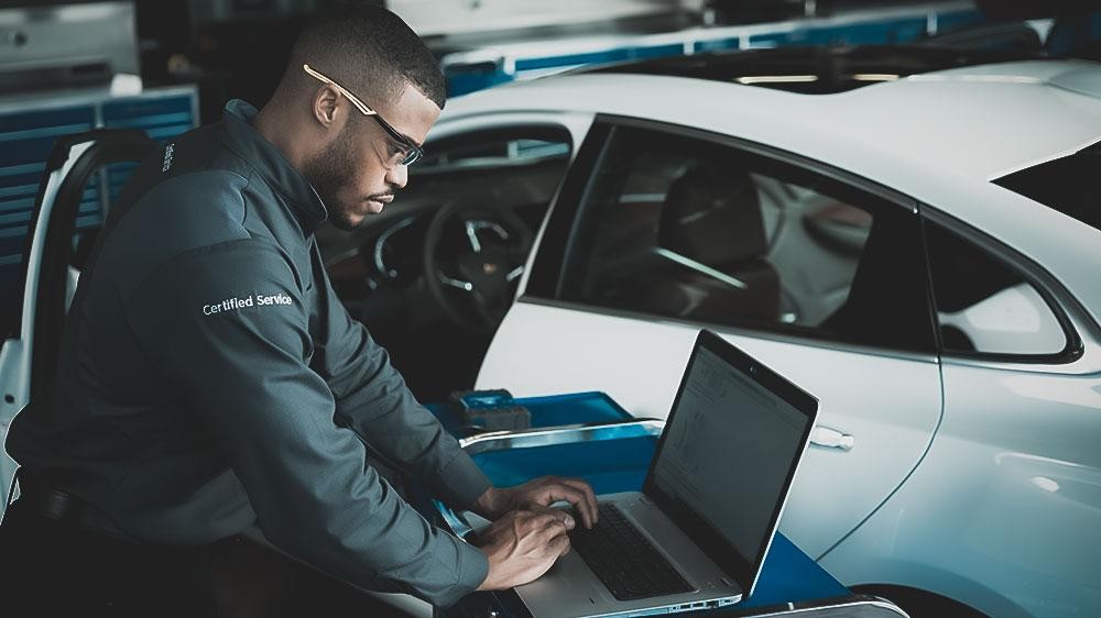 Service mechanic greeting a woman at her door and a mechanic working on a vehicle in a garage