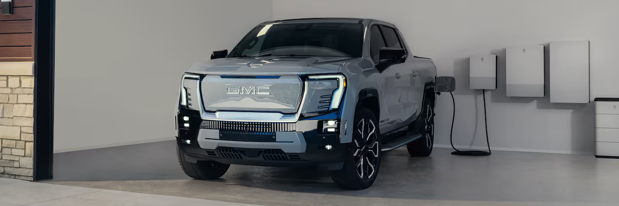 The 2025 GMC Sierra EV charging in a garage